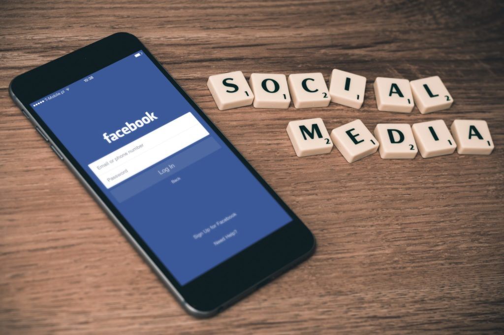 phone and scrabble tiles spelling out social media