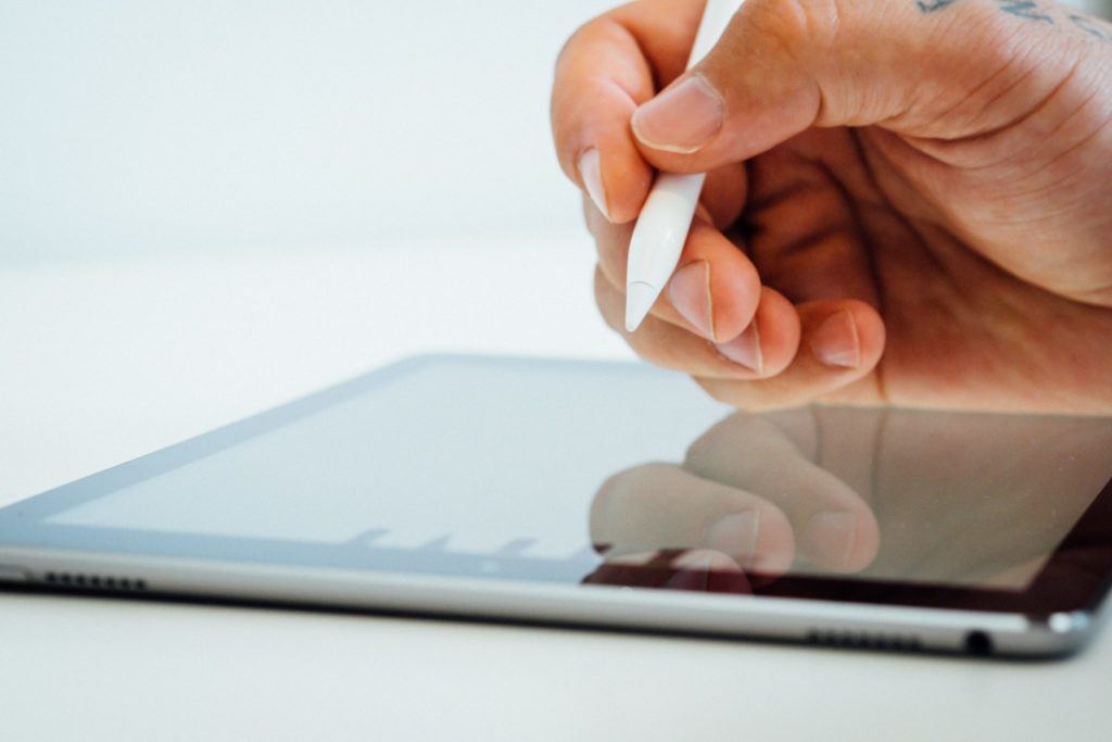 Man writing on tablet with stylus