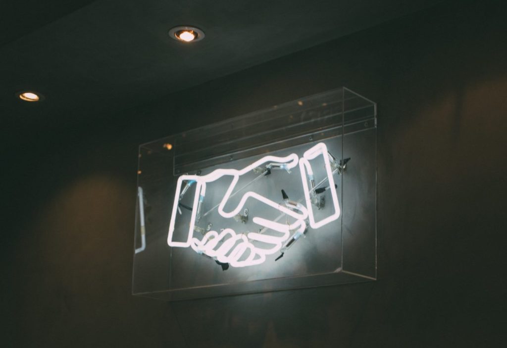 neon sign of a handshake